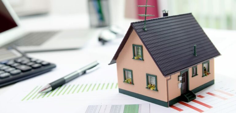 A model of a house is sitting on top of a piece of paper, representing the concept of mortgages.