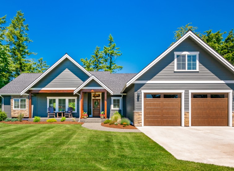 A home with two garages and a grassy yard that exudes curb appeal.