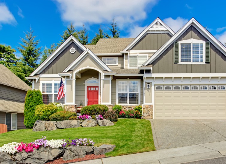 Enhance the curb appeal of a home with a garage and lawn.