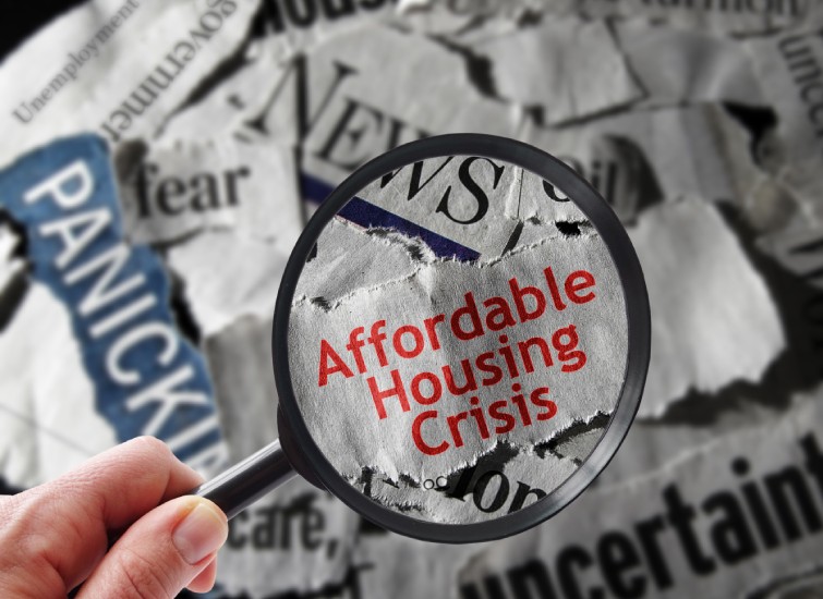 Affordable housing crisis - a hand holding a magnifying glass.