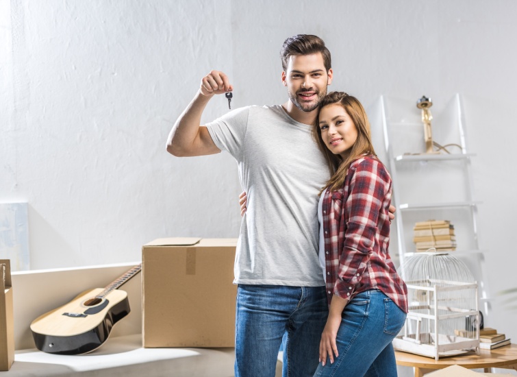 Young couple holding the keys to their new home stock photo.