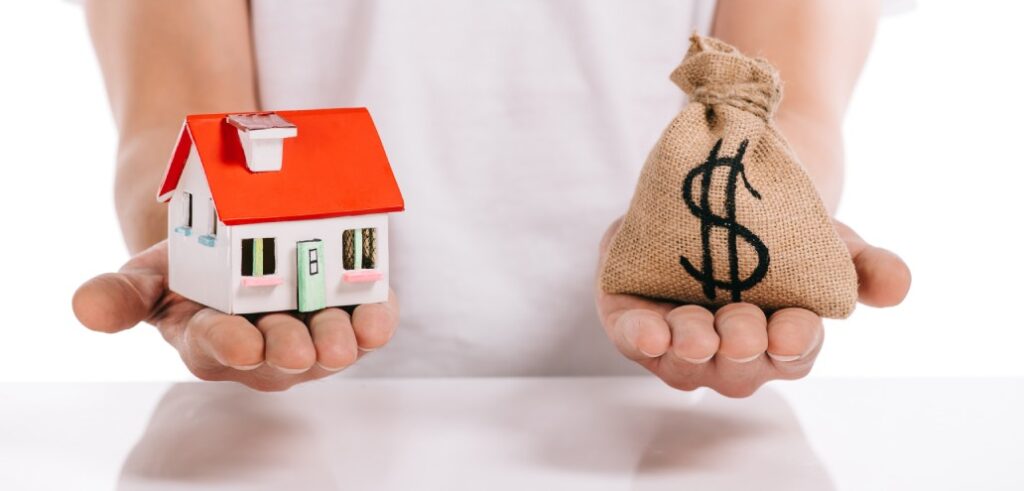 A person holding a house model and money bag for retirement planning.