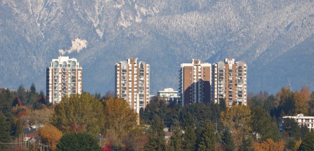 A group of apartment buildings with mountains in the background.