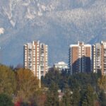 A group of apartment buildings with mountains in the background.