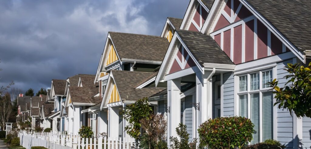 A row of houses with a white picket fence.