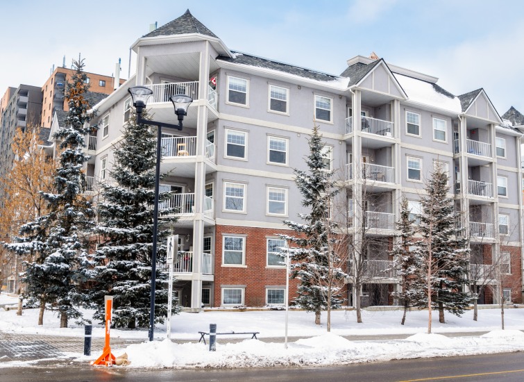 A large apartment building with snow on the ground.
