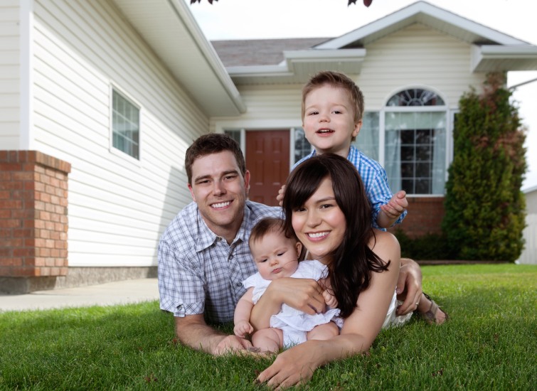 Family with two children posing in front of their home during Calgary Rezoning Discussions.
