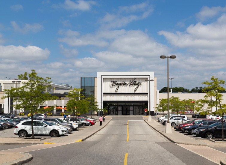 Exterior view of boscov's department store with a busy parking lot under a clear blue sky with clouds.
