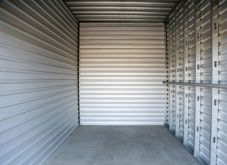 Empty metal storage unit with a closed door.