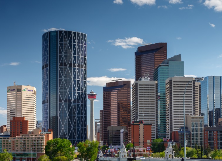 Skyline of Calgary, Canada, showcasing modern skyscrapers and the Calgary Tower under a clear blue sky, ideal for real estate investments.